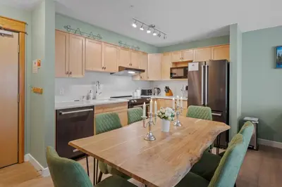 a kitchen with a wooden table and green chairs at 2 Bedroom Condo Banff, Canmore sleeps 6 comfortably in Canmore