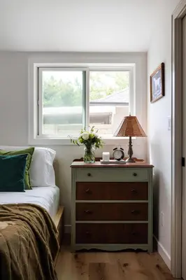 a bedroom with a bed and a dresser with a window at The Garden Studio in Victoria