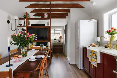 a kitchen with a table with chairs and a refrigerator at The Garden Studio in Victoria