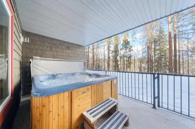 a hot tub on a balcony with a view of trees at 2BR Kimberley Escape with Private Hot Tub and BBQ in Kimberley