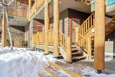 a house with wooden stairs in the snow at 2BR Kimberley Escape with Private Hot Tub and BBQ in Kimberley