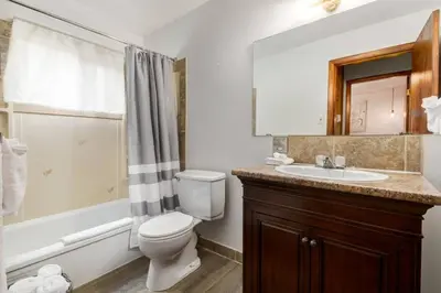 a bathroom with a toilet and a sink and a tub at Eagles Nest Chalet with Private Deck Near Banff in Canmore