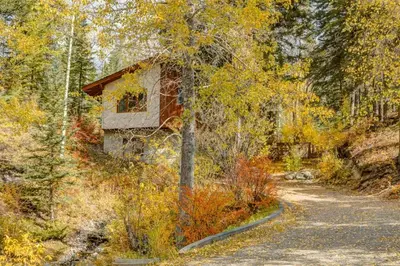 a cabin in the woods on a dirt road at Eagles Nest Chalet with Private Deck Near Banff in Canmore