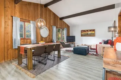 a dining room with a table and chairs and a living room at Eagles Nest Chalet with Private Deck Near Banff in Canmore