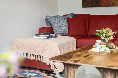 a living room with a red couch and a coffee table at Eagles Nest Chalet with Private Deck Near Banff in Canmore