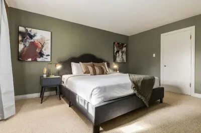 a bedroom with a large bed with green walls at 2BR Red Cedar Lodge near Banff with Mountain Views in Canmore