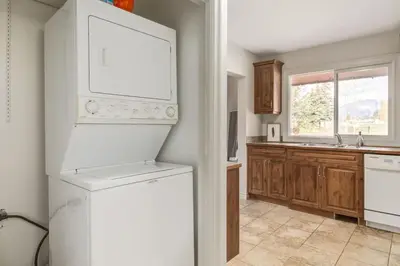 a kitchen with a white refrigerator and a dishwasher at 2BR Red Cedar Lodge near Banff with Mountain Views in Canmore