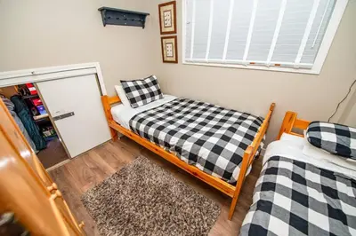 a bedroom with two bunk beds and a window at 3BR Oasis Private Hot Tub and Sauna Walk to Ski Hill in Kimberley
