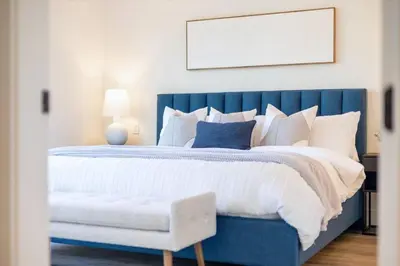 a bedroom with a blue bed with a blue headboard at Luxurious 4BR Beach Retreat with Backyard and Balcony in Penticton