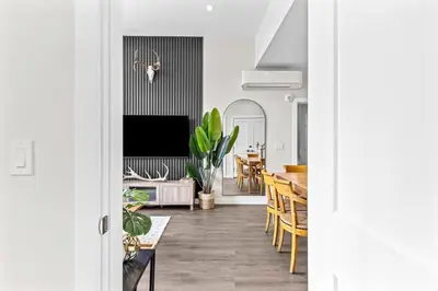 a living room and dining room with a dining table at Luxe 3BR Golden Hideaway Top Floor, Balcony & BBQ in Golden