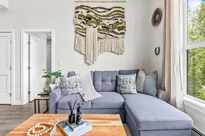 a living room with a blue couch and a table at Luxe 3BR Golden Hideaway Top Floor, Balcony & BBQ in Golden