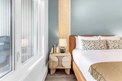 a bedroom with a bed and a table with a lamp at Scenic Riverstone 2BR w/ Balcony + BBQ, Sleeps 6! in Golden