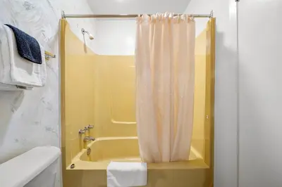 a bathroom with a tub and a shower curtain at Charming 1BR Near DT Kimberley: Pool, Hot Tub, Gym in Kimberley