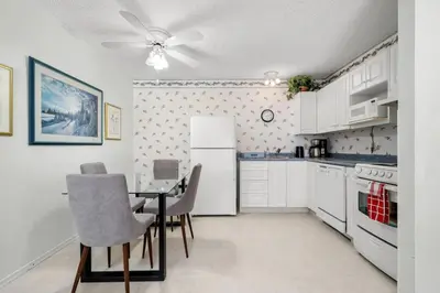 a kitchen with a table and chairs and a refrigerator at Charming 1BR Near DT Kimberley: Pool, Hot Tub, Gym in Kimberley
