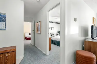 a hallway leading to a bedroom with a bed and a mirror at Charming 1BR Near DT Kimberley: Pool, Hot Tub, Gym in Kimberley