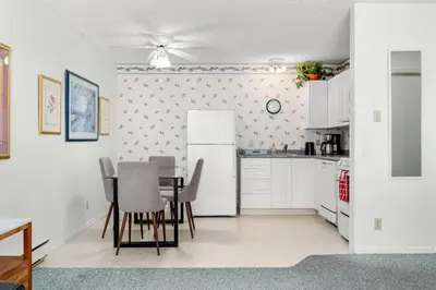 a kitchen with a table and a refrigerator at Kimberley Escape: 1BR+Studio w/ Hot Tub, Pool, BBQ in Kimberley