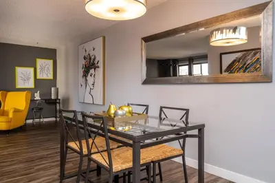 a dining room with a black table and chairs at Stylish DT Condo ~2 Blocks from Stampede Grounds in Calgary