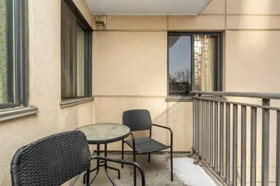 a balcony with two chairs and a table and a window at Stylish DT Condo ~2 Blocks from Stampede Grounds in Calgary