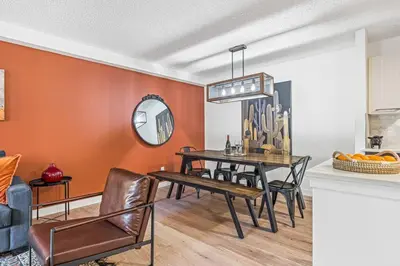 a dining room with orange walls and a table and chairs at Stampede Modern downtown Condo Spacious 2BR in Calgary