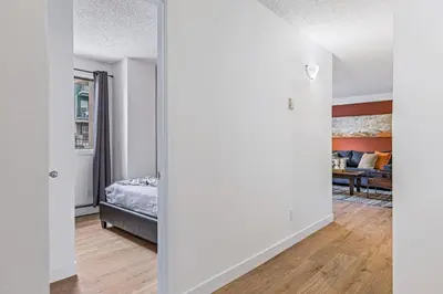 a bedroom with a bed and a living room at Stampede Modern downtown Condo Spacious 2BR in Calgary