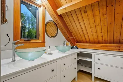 a bathroom with two sinks and a window at Highlands Homestead Luxury Retreat in Bragg Creek