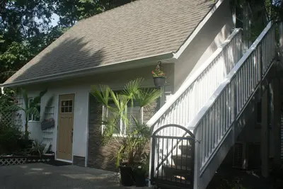 a white house with a porch and a door at Nesting Ravens cottage in Nanaimo
