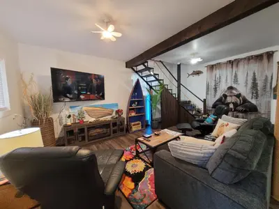 a living room with a couch and a staircase at Nesting Ravens cottage in Nanaimo