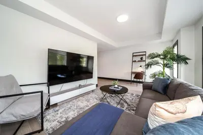 a living room with a large flat screen tv at Luxury Sleeps 10 King bed Jacuzzi 10 Min to West Edmonton Mall in Edmonton
