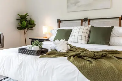 a bed with a green and white blanket on it at Luxury Sleeps 10 King bed Jacuzzi 10 Min to West Edmonton Mall in Edmonton