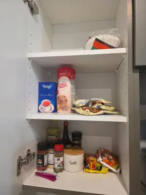 a refrigerator with food and other items in it at Amaville Suites - One Bedroom in West Edmonton in Edmonton