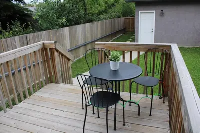 a patio with two chairs and a table on a deck at Modern Vacation Home Near West Edmonton Mall, Transit Center & LRT - 3BR in Edmonton