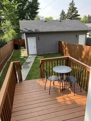 a wooden deck with a table and chairs on it at Modern Vacation Home Near West Edmonton Mall, Transit Center & LRT - 3BR in Edmonton
