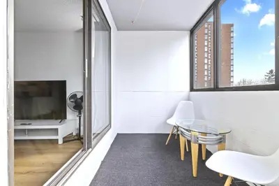 a living room with a glass table and a tv at Bright 2 Bedroom Suite at Victoria & Stampede Park in Calgary
