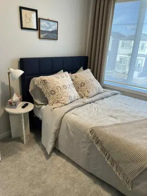 a bedroom with a bed with a window and a table at Northside Dream Home in Edmonton