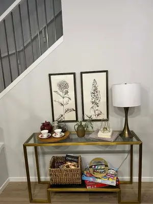 a console table with a lamp and pictures on the wall at Northside Dream Home in Edmonton