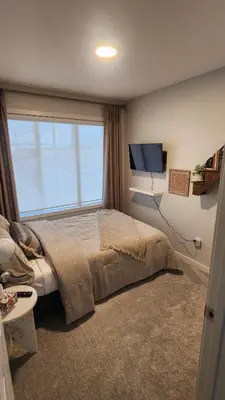 a bedroom with a bed and a large window at Northside Dream Home in Edmonton