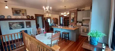 a kitchen and living room with a table and a counter at Rosewood in New Westminster