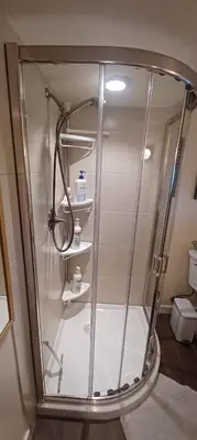 a shower stall in a bathroom with a toilet at Rosewood Garden Studio in New Westminster