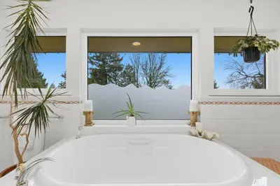 a bath tub in a bathroom with a window at Entire Spanish Style Villa 5 Bedrooms near Ocean in West Vancouver