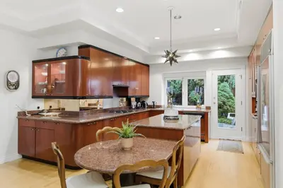 a kitchen with wooden cabinets and a table at Entire Spanish Style Villa 5 Bedrooms near Ocean in West Vancouver