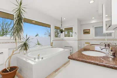 a bathroom with a large tub and a large window at Entire Spanish Style Villa 5 Bedrooms near Ocean in West Vancouver