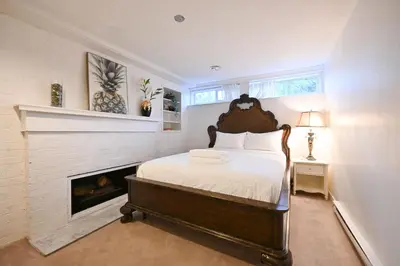 a bedroom with a large bed and a fireplace at Basement Suite in South Vancouver in Vancouver