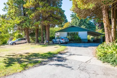 a house with two cars parked in a driveway at Basement Suite in South Vancouver in Vancouver