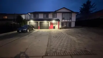 a car parked in front of a house with a garage at J & J Dream Villa Ltd in Abbotsford