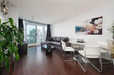 a living room with a couch and a table and chairs at Cozy Condo in Prime Location with Jacuzzi Pool & Sauna in Vancouver