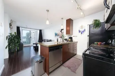 a kitchen with a stove and a refrigerator at Cozy Condo in Prime Location with Jacuzzi Pool & Sauna in Vancouver