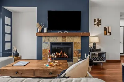 a living room with a fireplace and a tv at Heart of Canmore Condo managed by Little Sister Getaways in Canmore