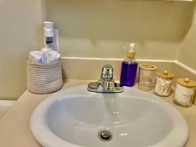 a bathroom sink with a faucet and some towels at AK Stay in Abbotsford