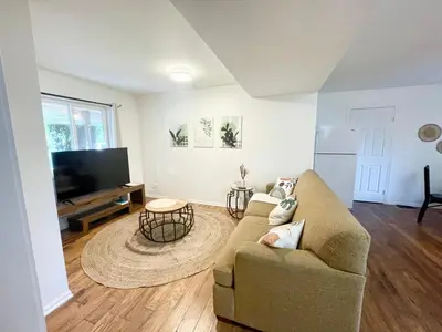 a living room with a couch and a flat screen tv at AK Stay in Abbotsford