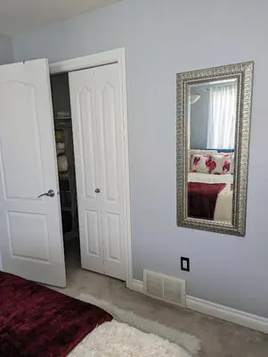 a white room with a mirror and a red rug at The Love Home Stay in Edmonton